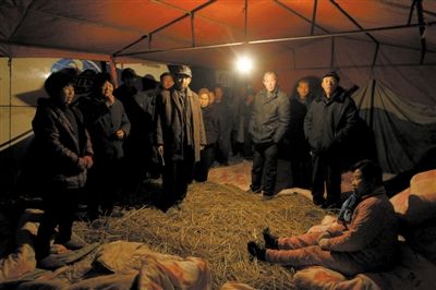 昨日，安徽颍上县迪沟镇，村民在扣留的大巴车旁搭起帐篷。新京报记者