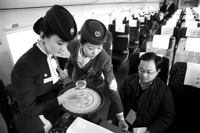 昨日，京广高铁试跑。在列车上，乘务员正给乘客倒水。 本版摄影/新京报记者 尹亚飞 摄